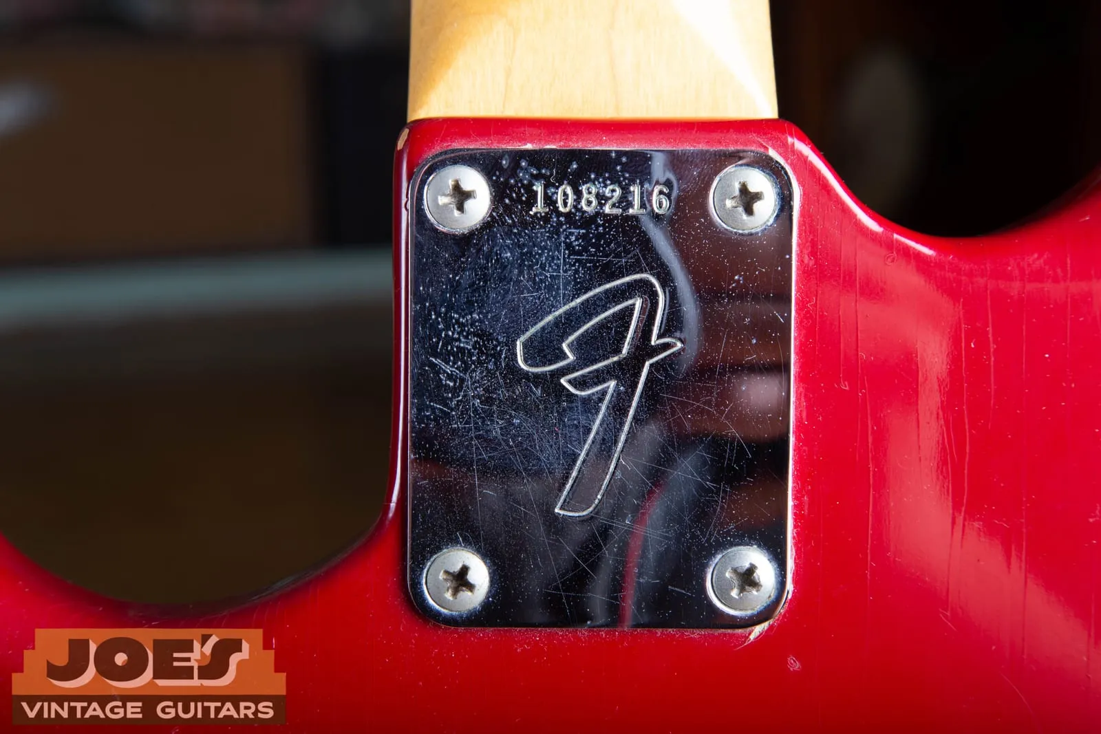 Back of a mid-1960s Fender Mustang neck showing the large F neck plate stamped with serial number 108216.