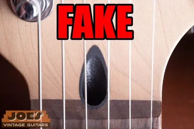 Fake Fender neck with a black plastic insert instead of the genuine walnut truss rod plug