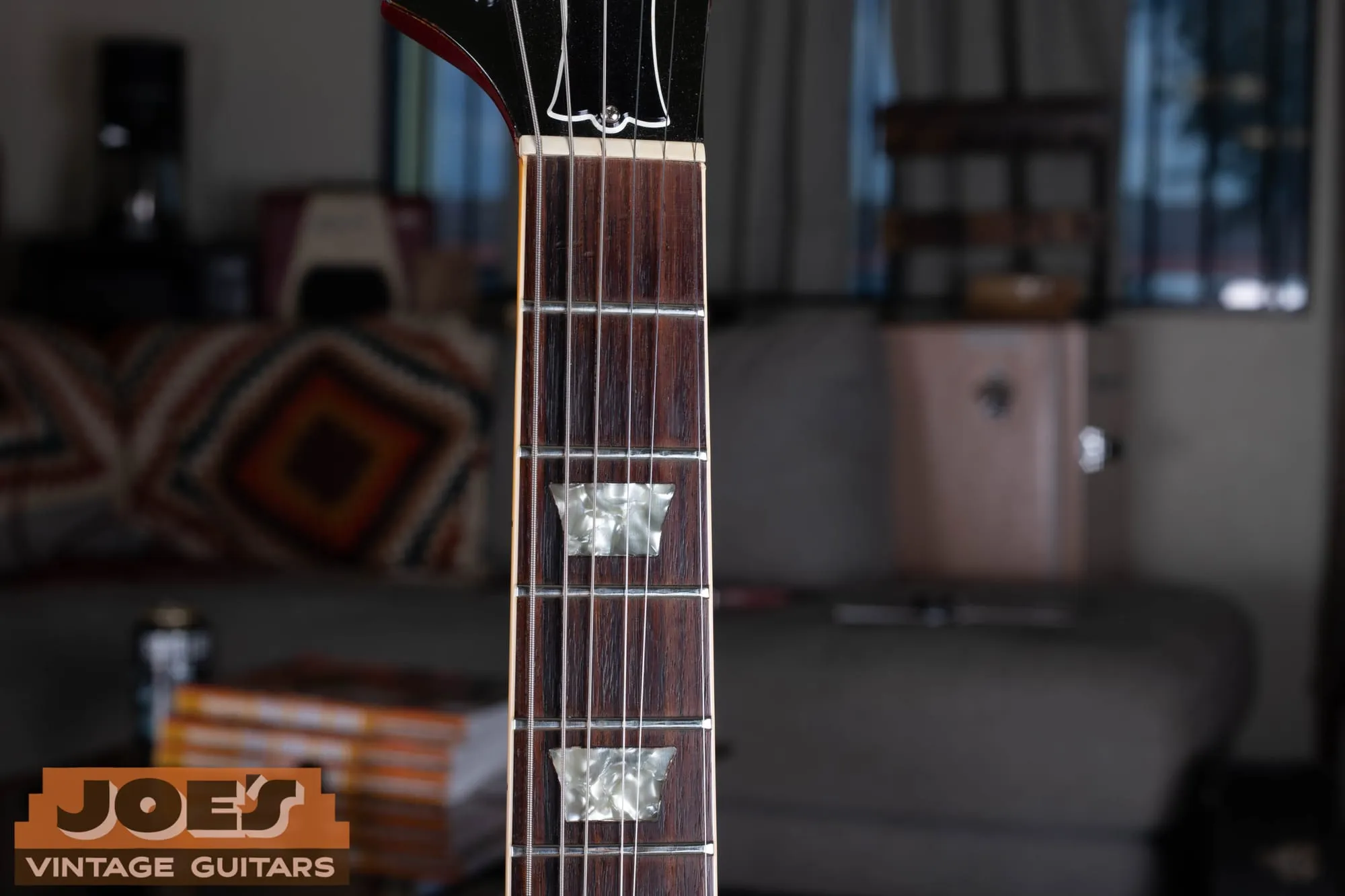 Bound rosewood fingerboard of a Gibson Aldo Nova Les Paul XPL, showing pearloid trapezoid inlays and cream binding.