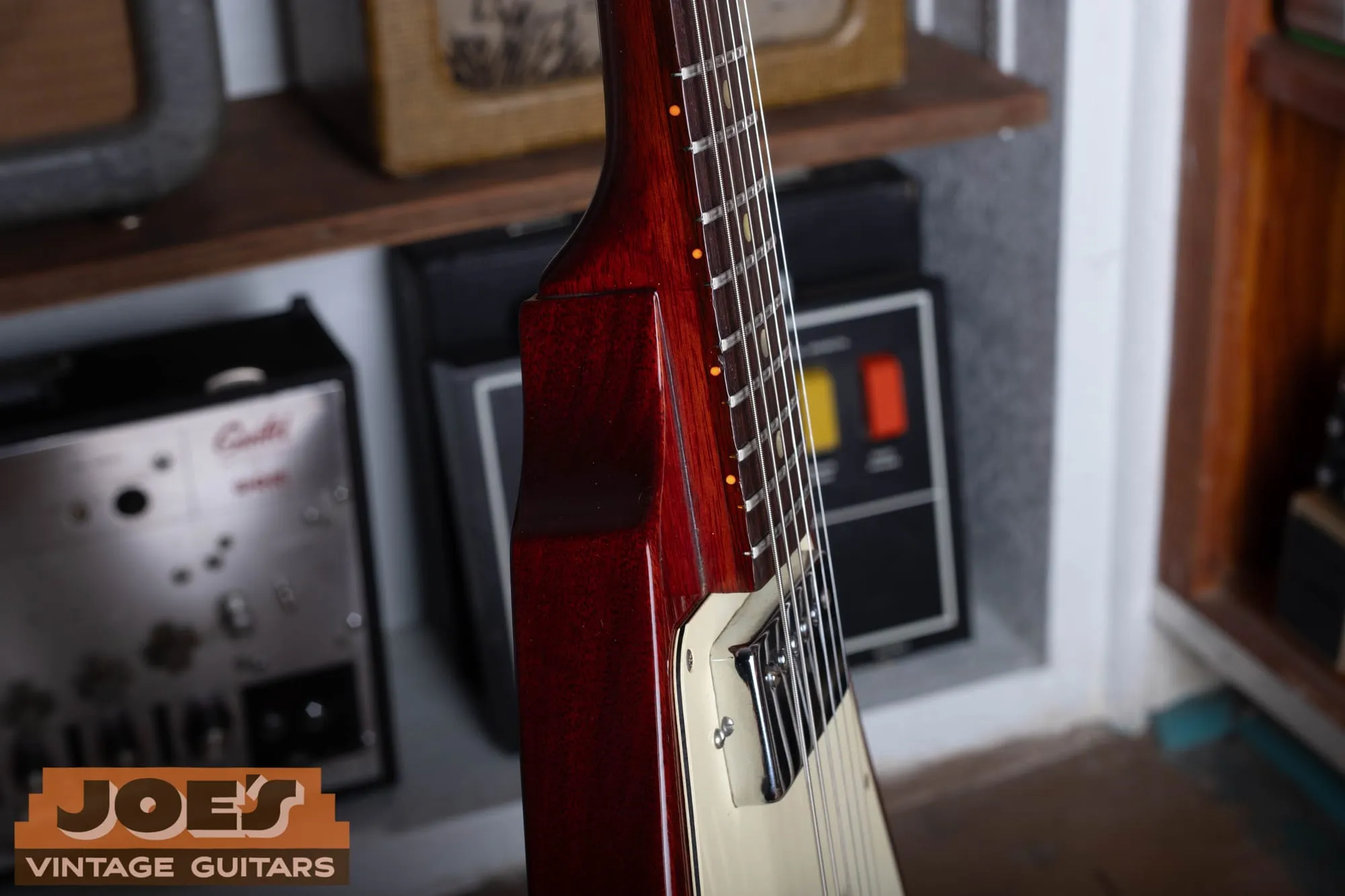 Side profile of a 1971 Gibson Flying V Medallion showing the thin, flat mahogany body, the cream pickguard edge, and the cherry finish.