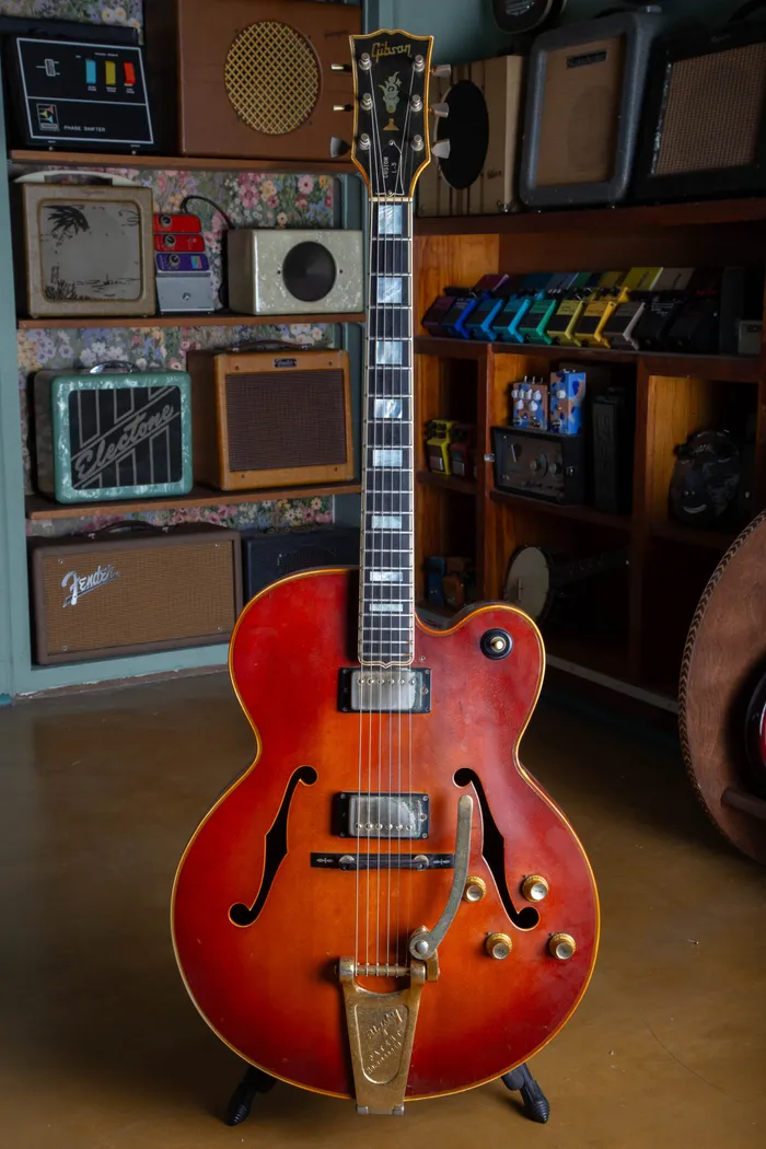 1969 Gibson L-5 CES hollow body electric guitar in a sunburst finish, featuring a Florentine cutaway, gold hardware, and a Bigsby vibrato tailpiece. The guitar is shown without a pickguard, highlighting the wood grain and dual humbucking pickups.