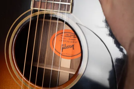 Vintage Gibson orange oval interior label showing handwritten serial number inside the body of the guitar