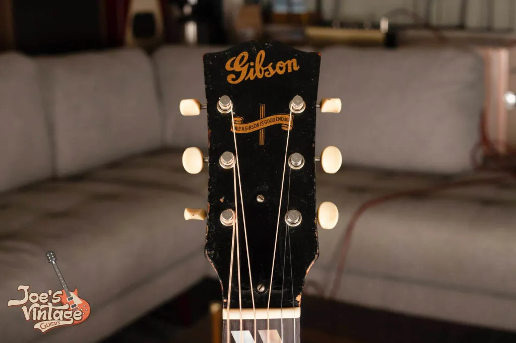 Close-up of a 1944 Gibson Southern Jumbo (SJ) headstock featuring the rare wartime gold Banner logo “Only a Gibson Is Good Enough” and the classic script Gibson logo.