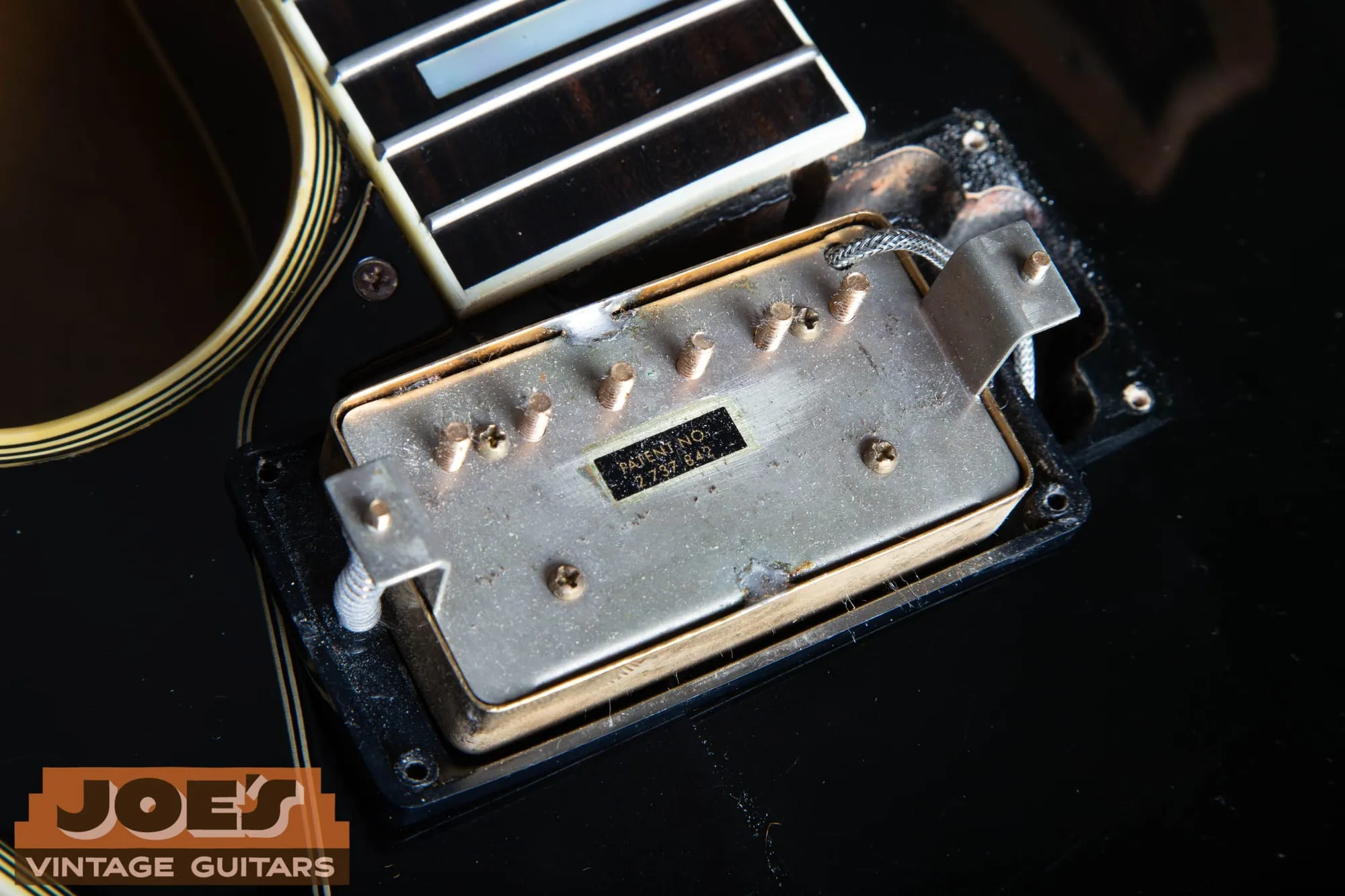 Gold plated Gibson patent number pickup from a Les Paul Custom showing factory brushing marks on the nickel silver baseplate.