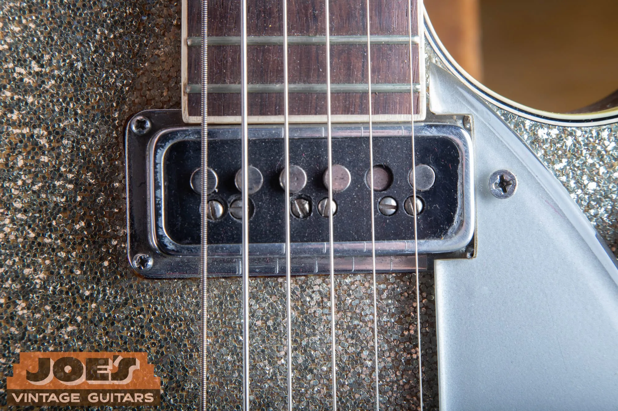 Close-up of a DeArmond Dynasonic single-coil pickup on a vintage Gretsch Jet, showing the single row of adjustable pole pieces.