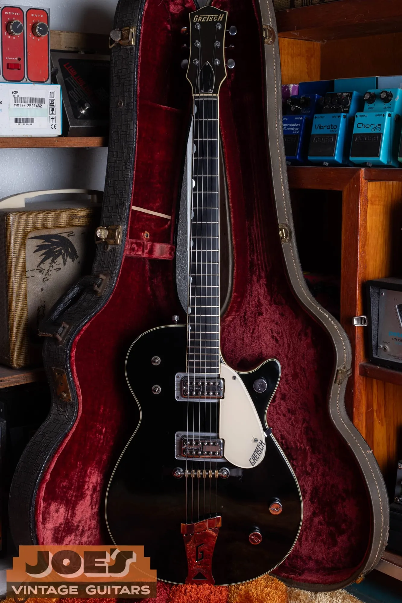 A black single-cutaway Gretsch Duo Jet 6128 photographed at an angle in its case, showing the two Filter’Tron pickups and thumbnail inlays.