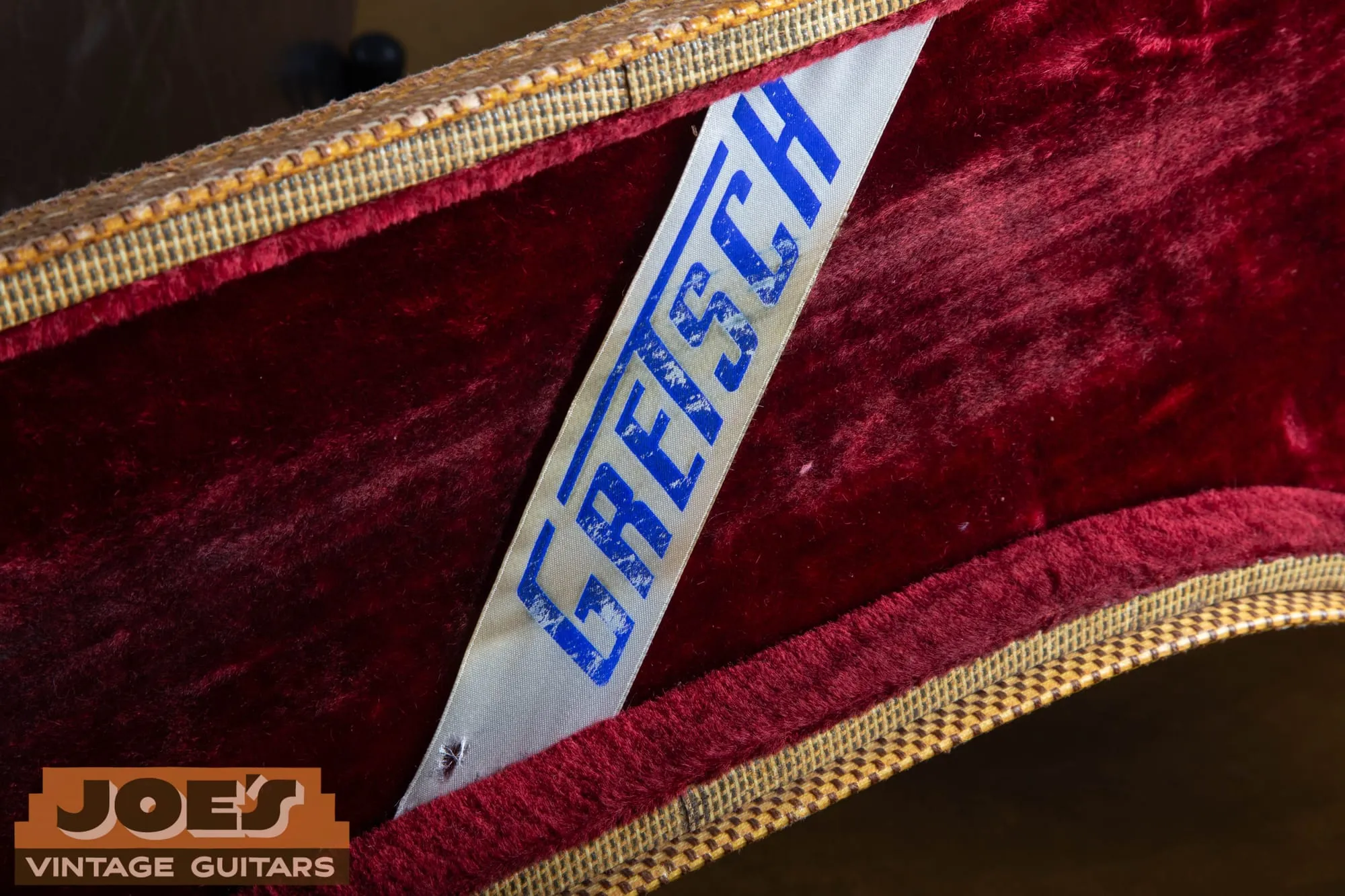 A vintage Gretsch hardshell case with the Gretsch logo, holding a vintage Silver Jet.