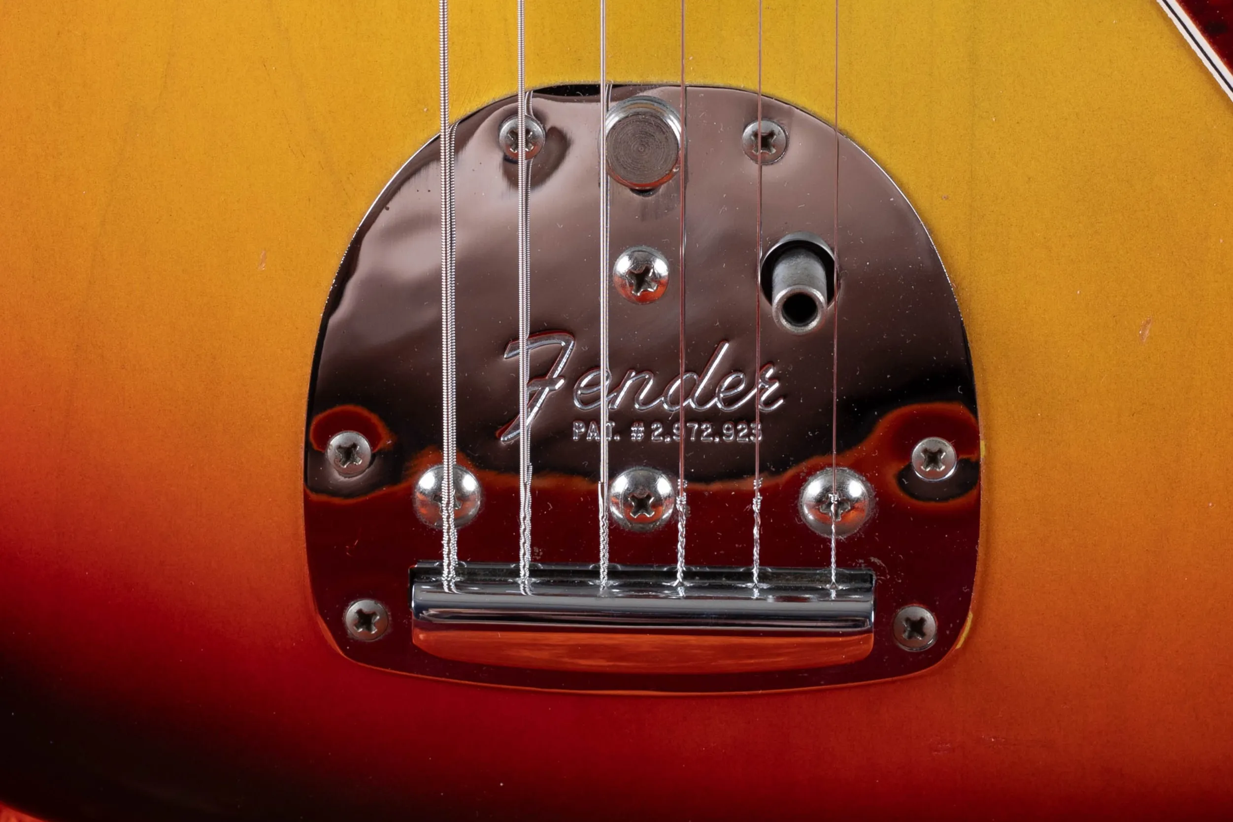 Fender Jazzmaster floating tremolo close-up, trem-lock button, chrome tremolo body, and tremolo arm socket showing period-correct Jazzmaster vibrato hardware
