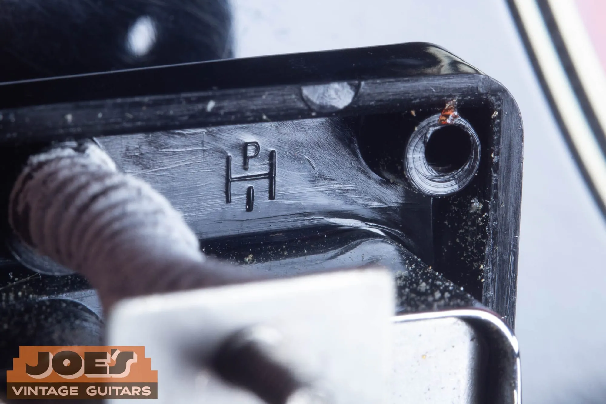 Molded letter stamps inside a vintage Gibson pickup mounting ring.