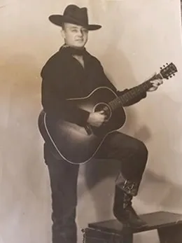 Walter M with his guitar at a radio station, 1945