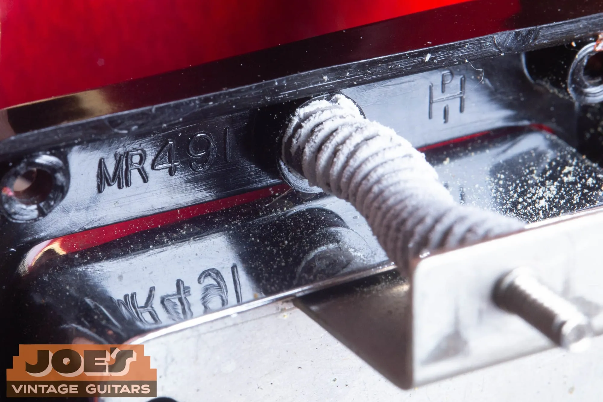 MR 491 mold marking inside a vintage Gibson pickup ring with the braided pickup lead crossing it.