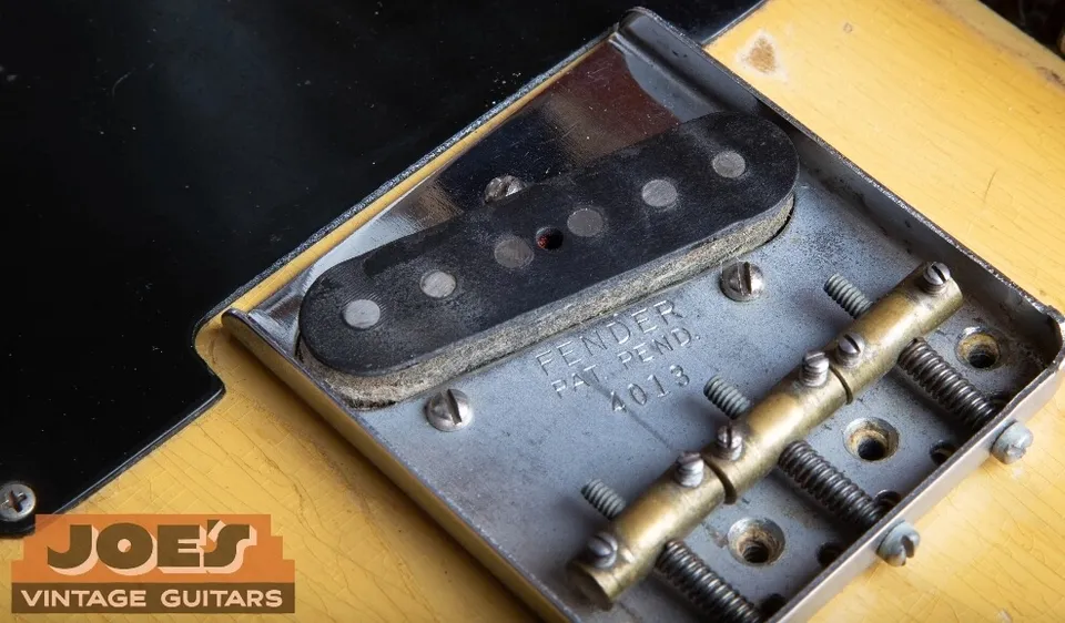 An early Fender Telecaster bridge pickup with flat, even pole pieces on a brass-saddle bridge